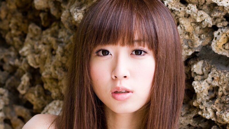 woman with brown hair against rock