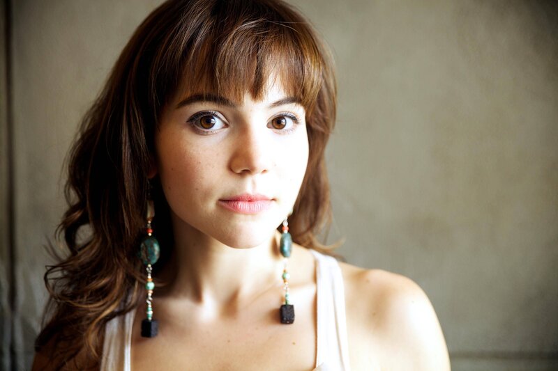 woman with brown hair and earrings