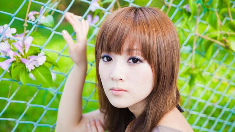 woman with brown hair by fence