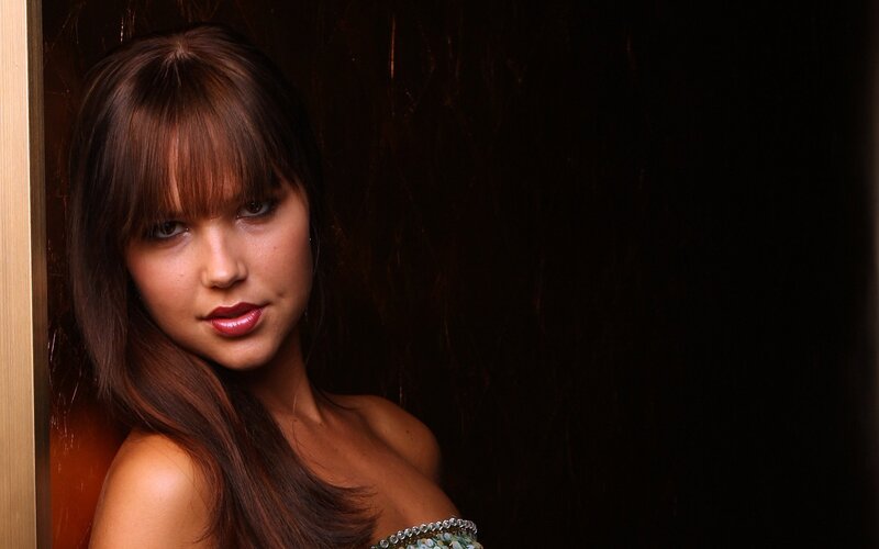 woman with brown hair in dark setting