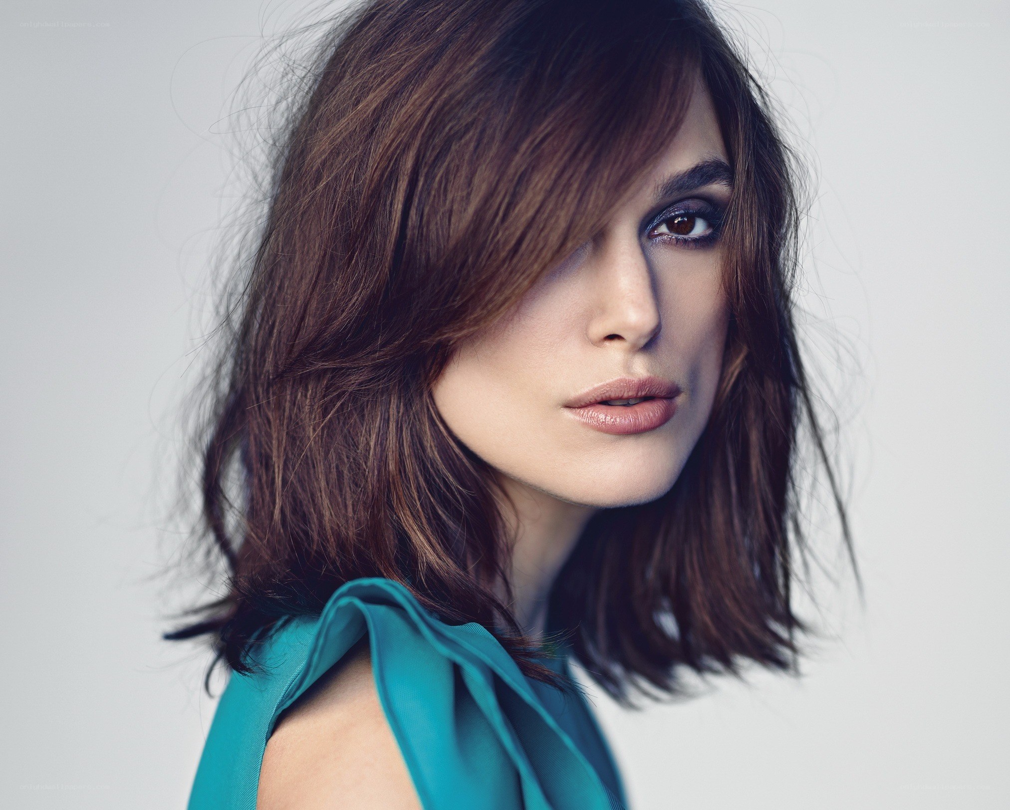 woman with brown hair in teal dress