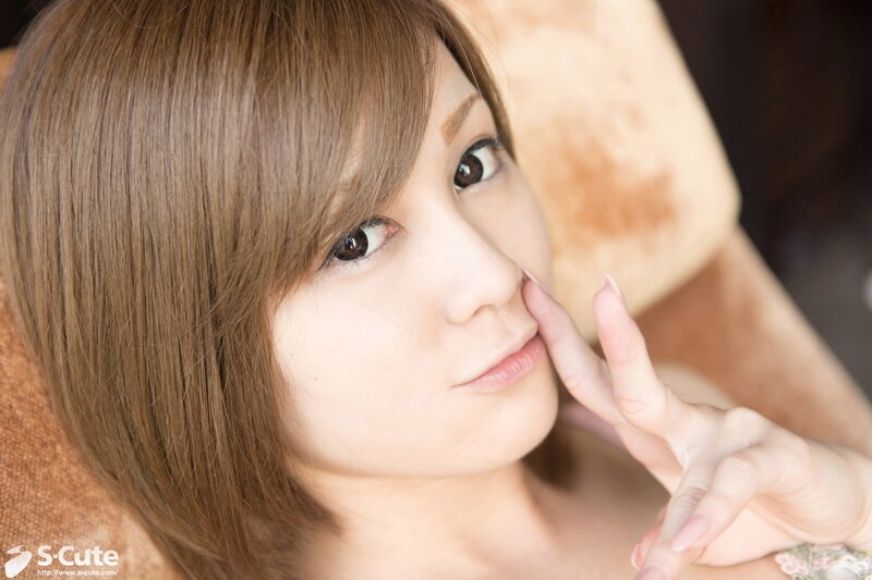 woman with brown hair touching her face
