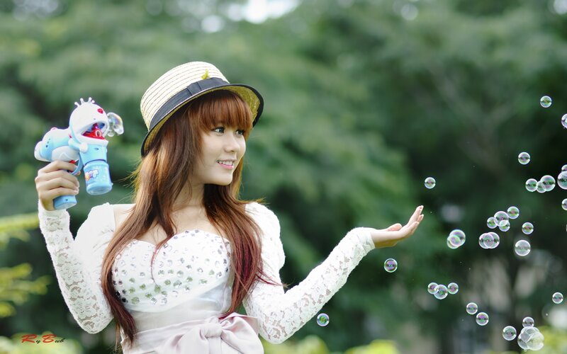 Woman with bubble gun in park