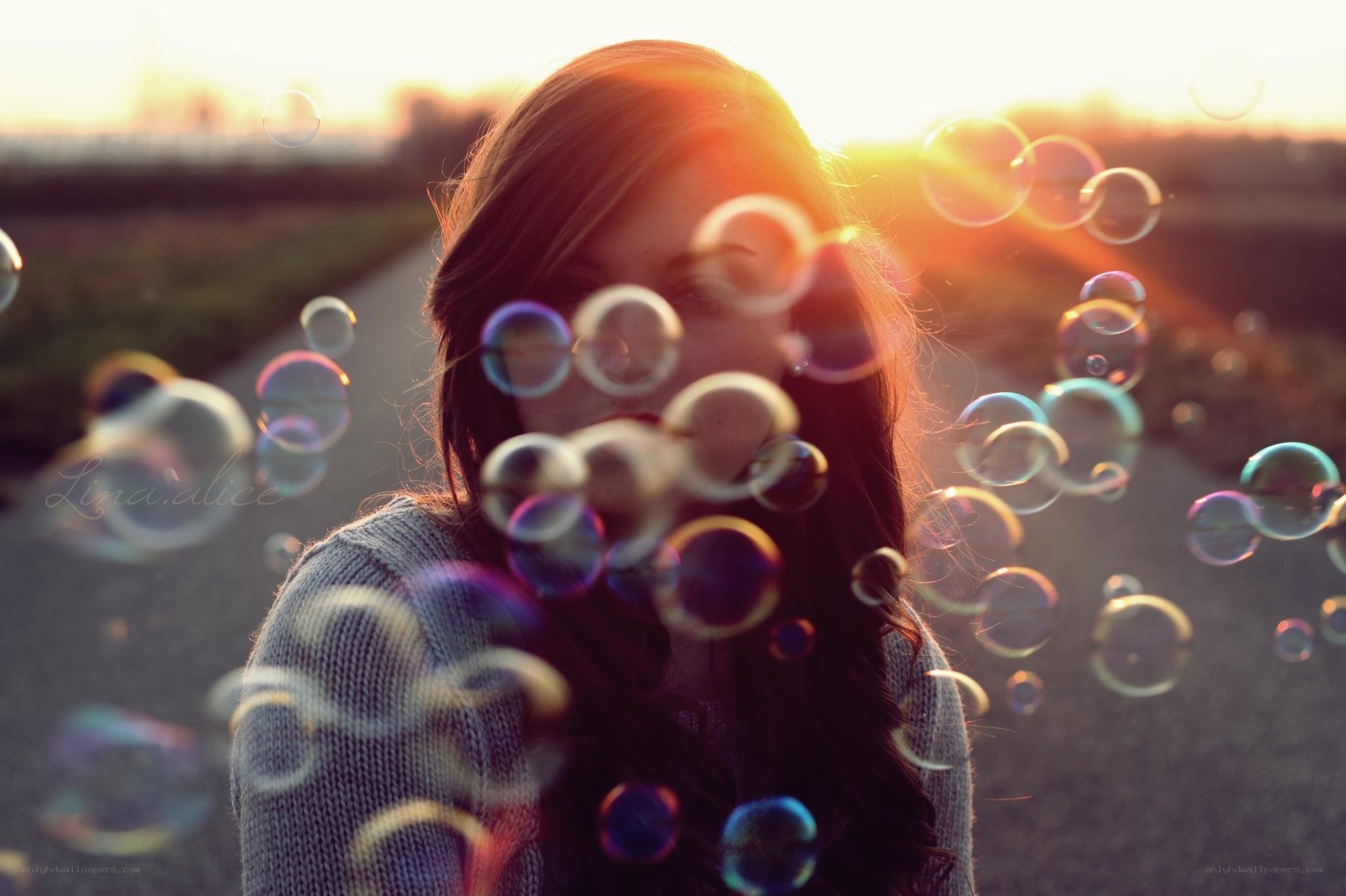 Woman with bubbles at sunset