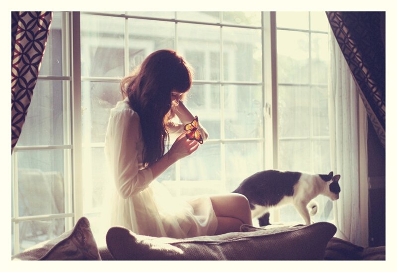 Woman with butterfly by window