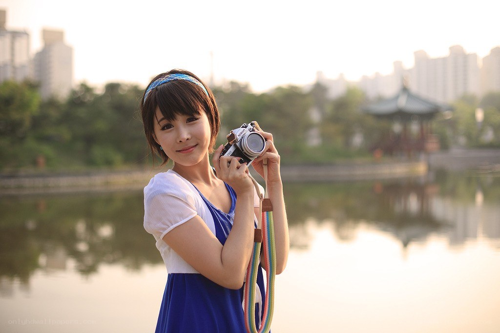 Woman with camera by lake
