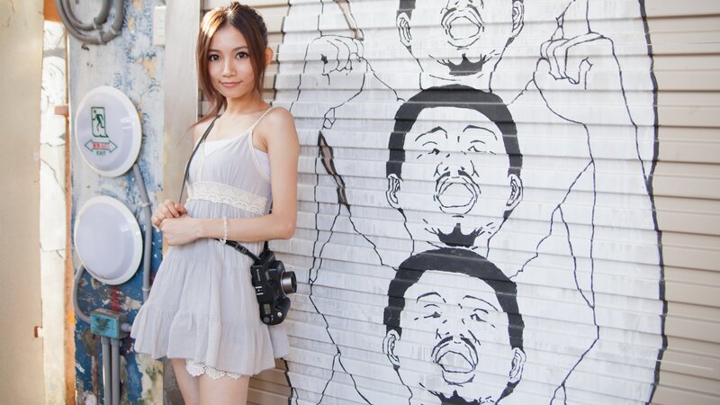 Woman with camera in front of graffiti