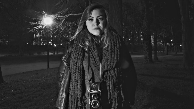 Woman with camera in park at night