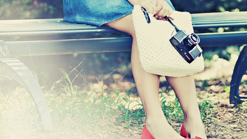 woman with camera on bench