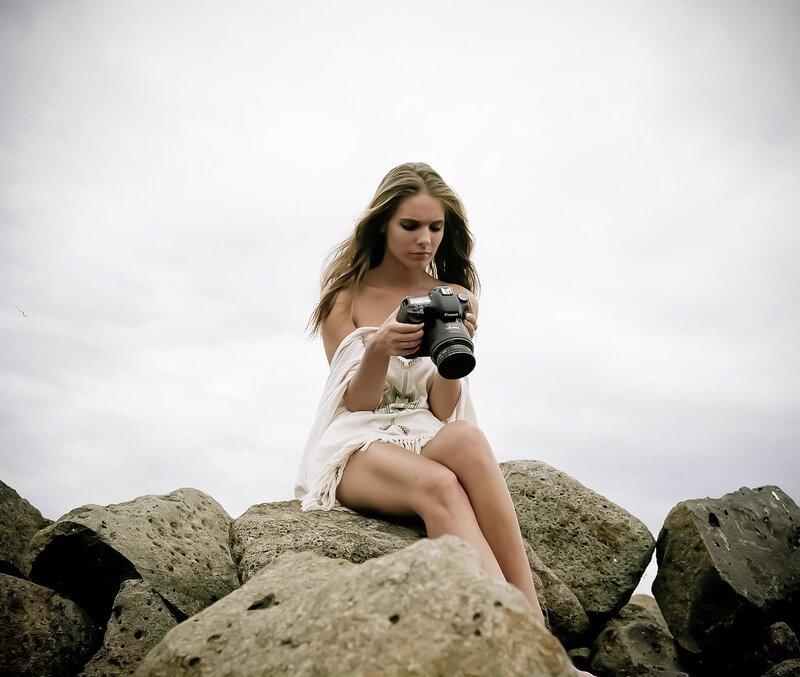 Woman with camera on rocks