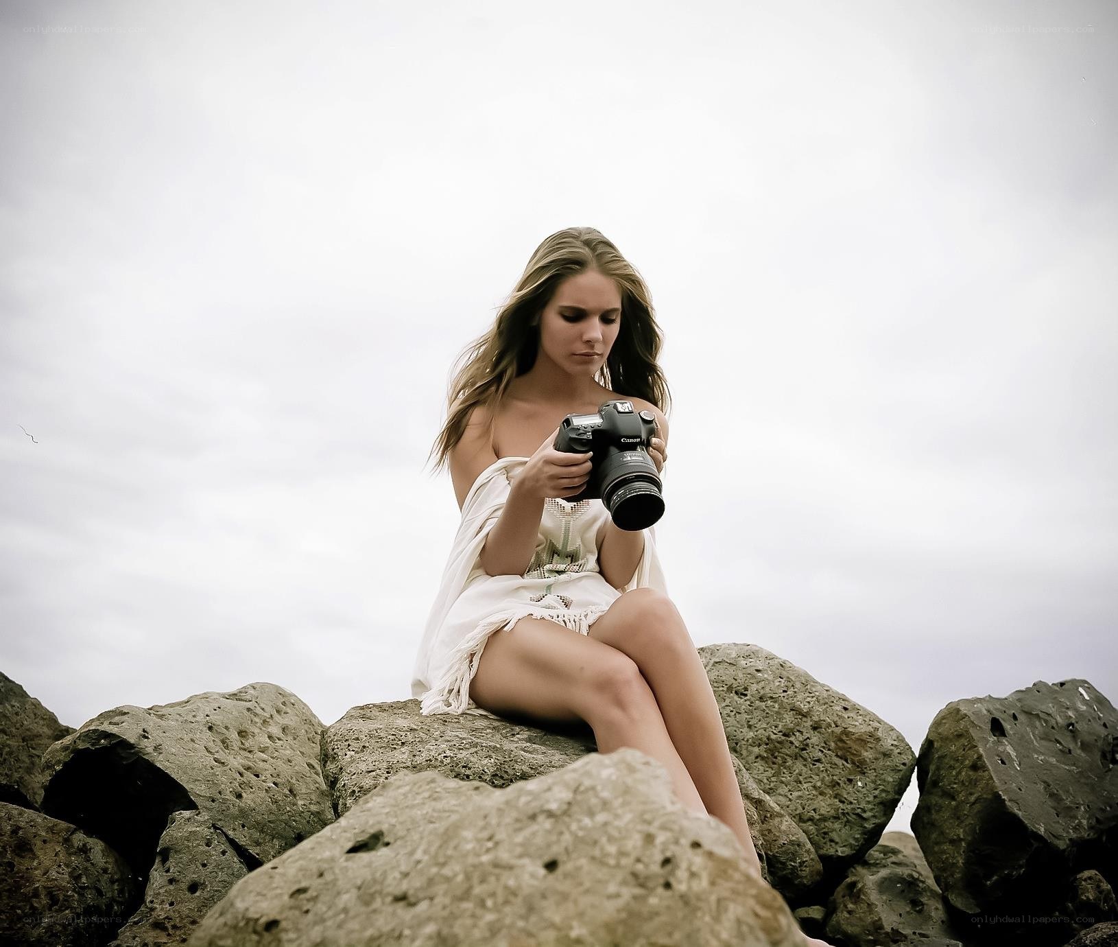 Woman with camera on rocks