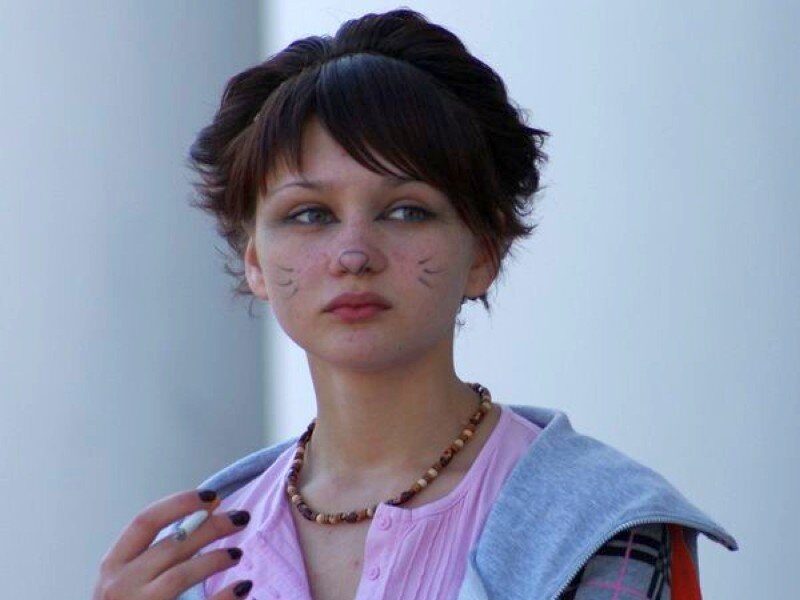 woman with cat makeup holding cigarette