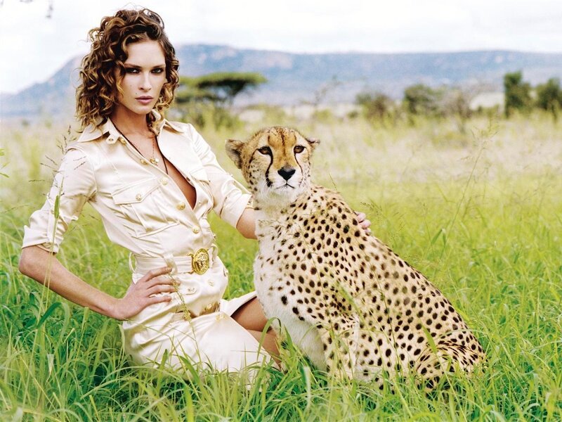 Woman with cheetah in field