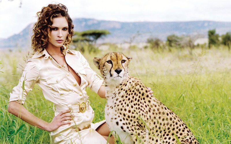 Woman with cheetah in savanna