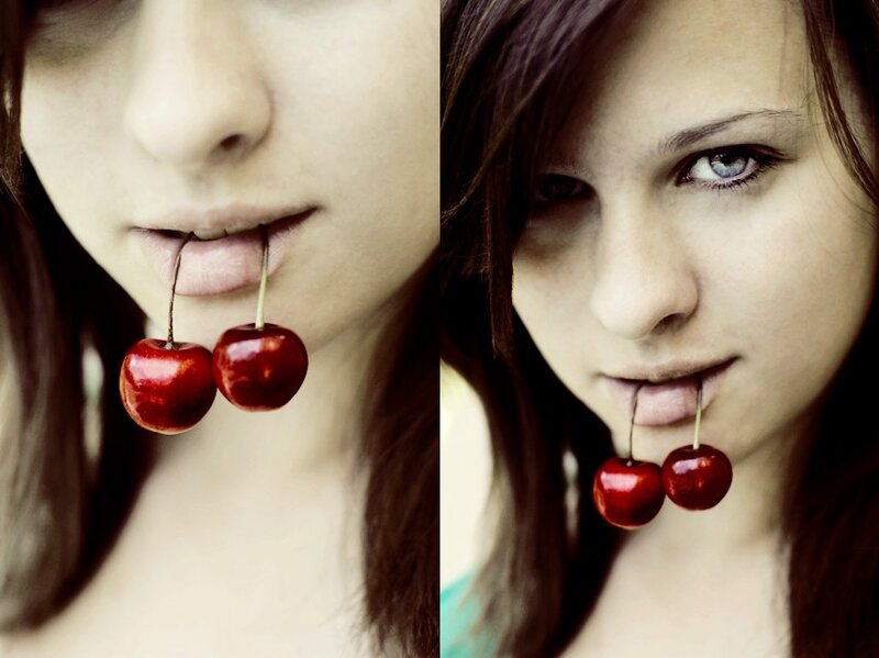 woman with cherries in her mouth