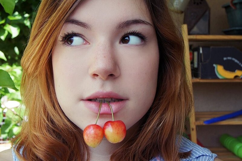 woman with cherries in mouth
