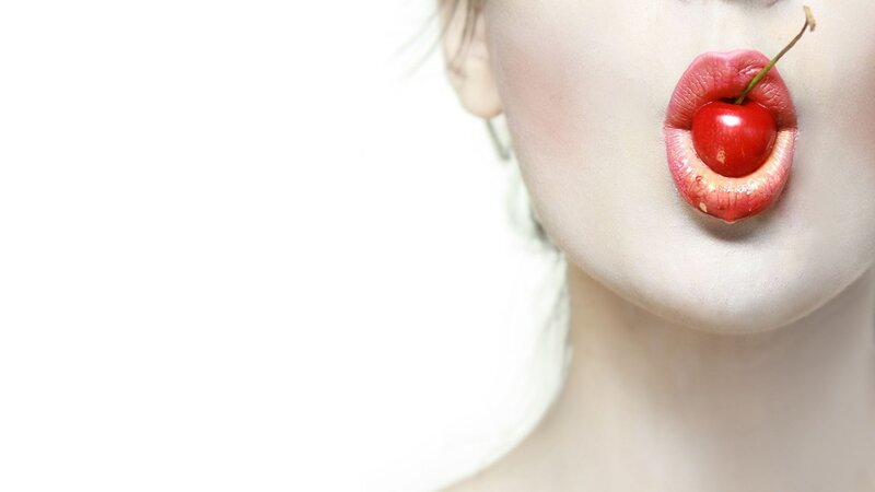 woman with cherry in mouth
