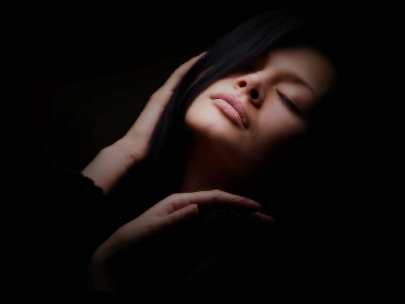 woman with closed eyes in darkness