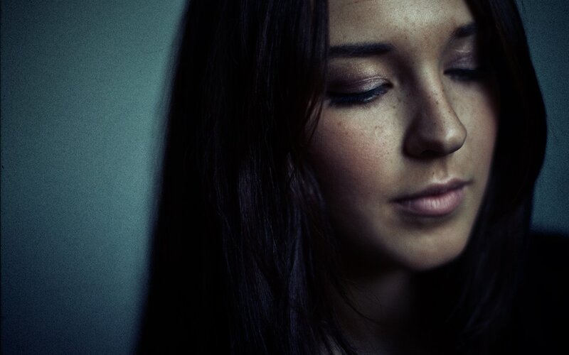 woman with closed eyes in dim light