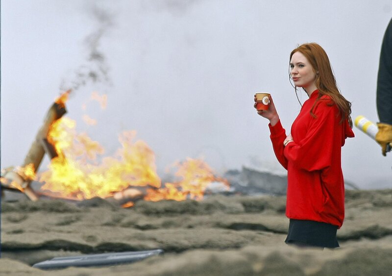 Woman with coffee near fire