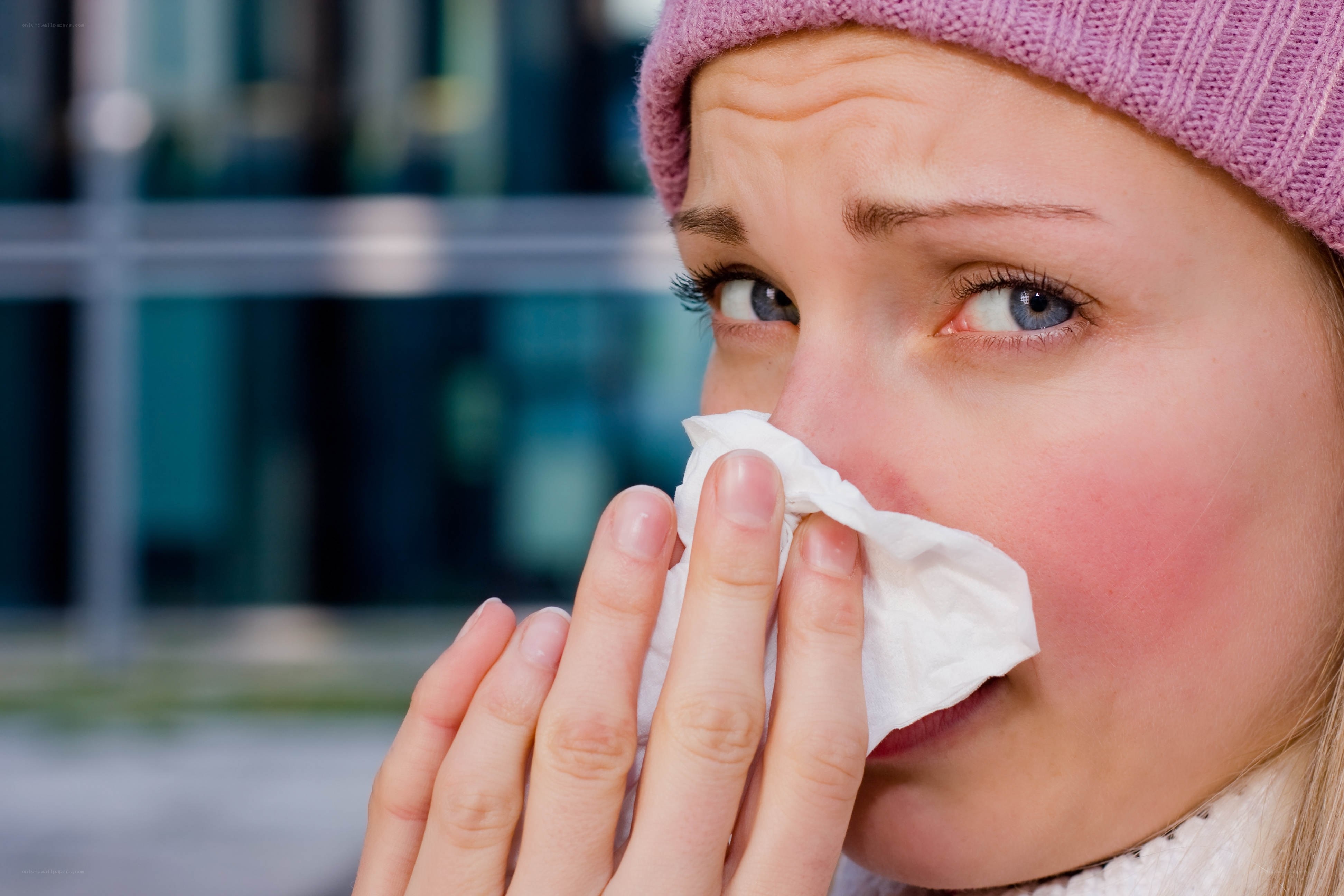 woman with cold using tissue