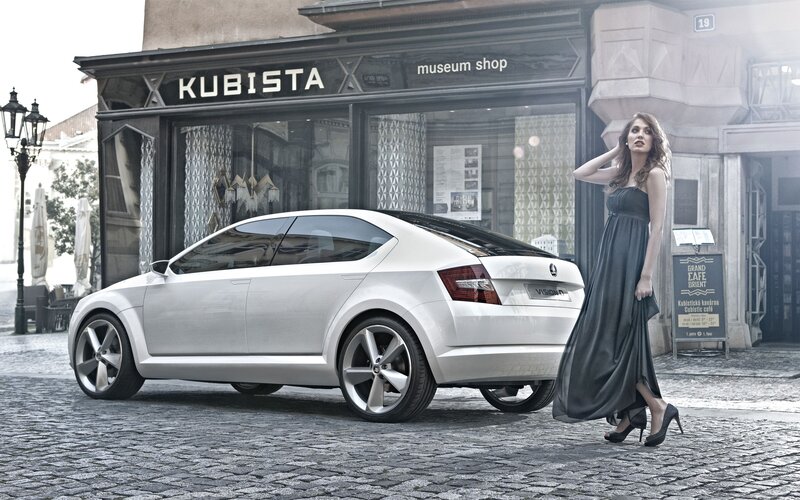 Woman with concept car on cobblestone street