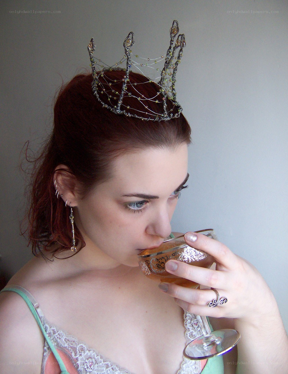 woman with crown drinking wine