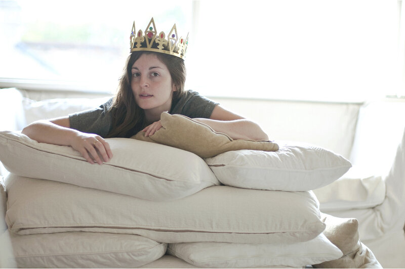 woman with crown on pillows