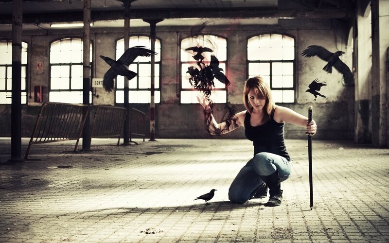 Woman with crows in abandoned building
