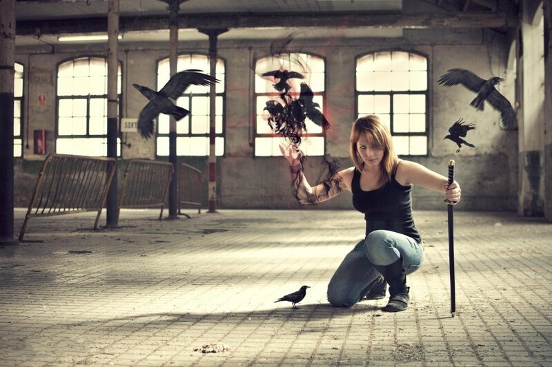 Woman with crows in an abandoned building