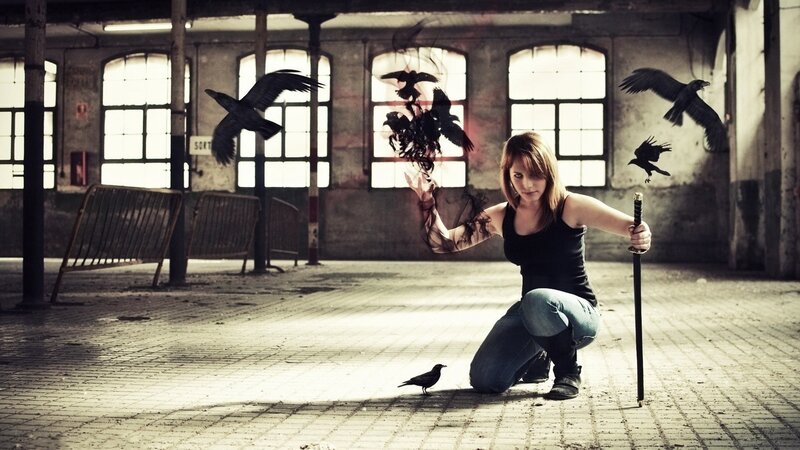 Woman with crows in an abandoned building