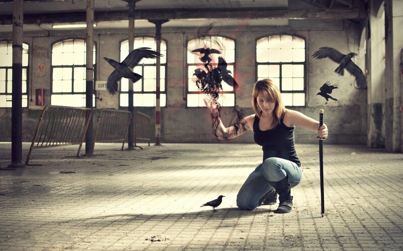 Woman with crows in an abandoned warehouse