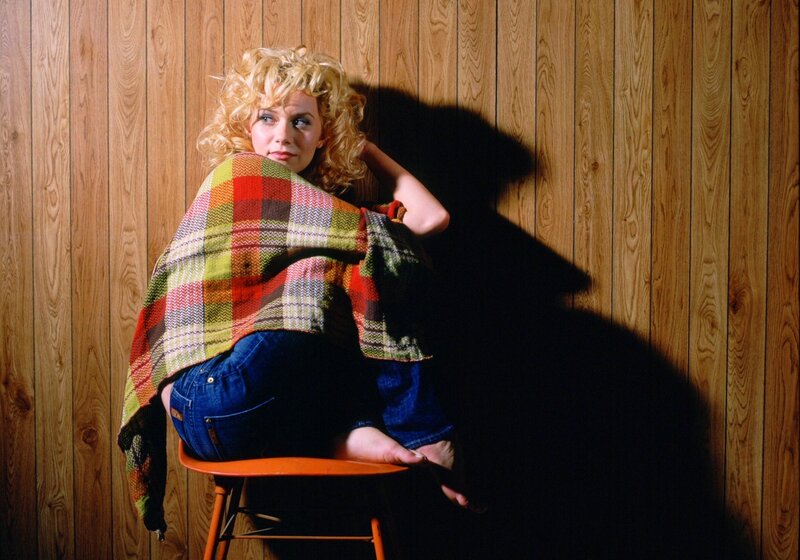 Woman with curly blonde hair on chair