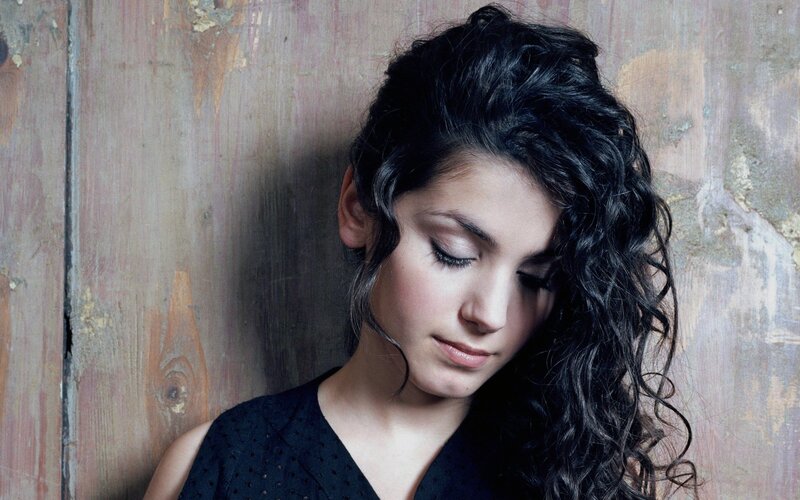 woman with curly hair against wood