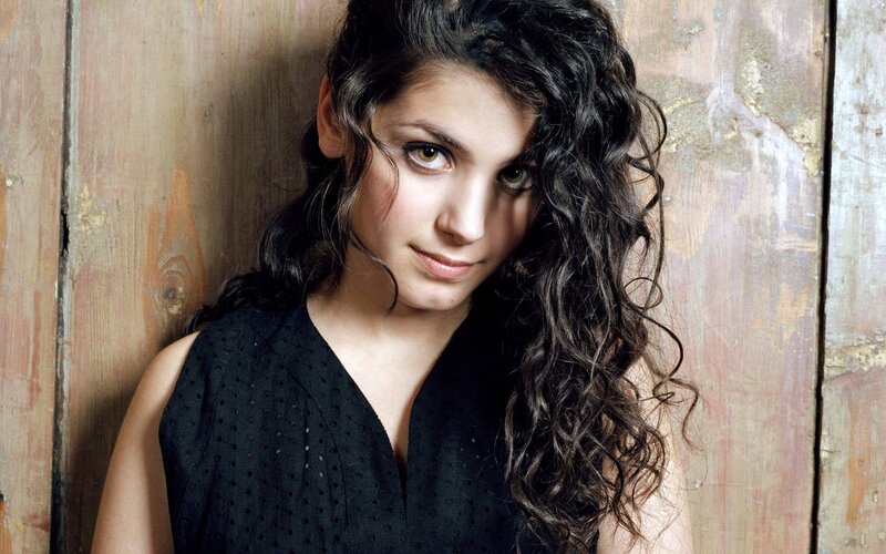 woman with curly hair against wood