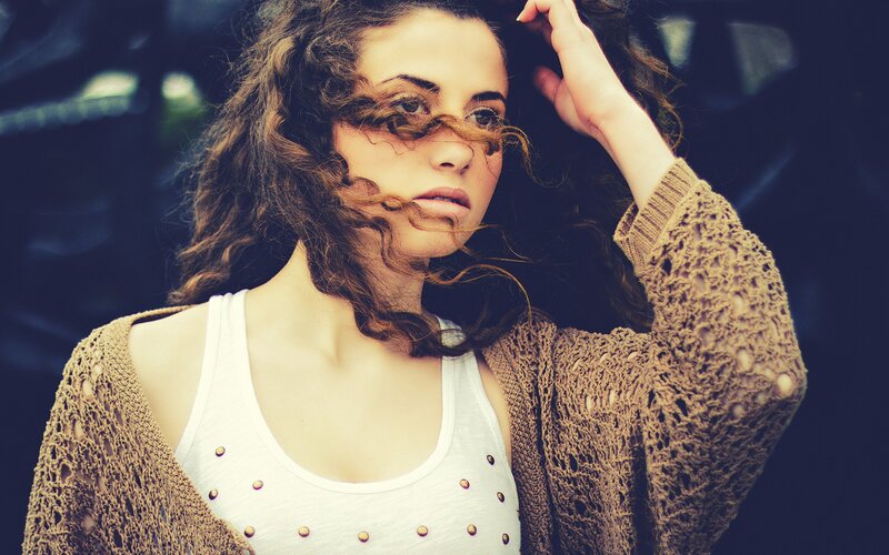 woman with curly hair and cardigan