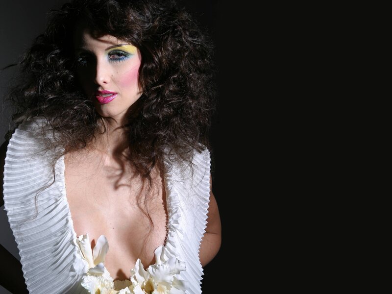 woman with curly hair and colorful makeup