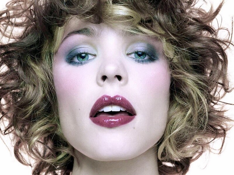 woman with curly hair and colorful makeup