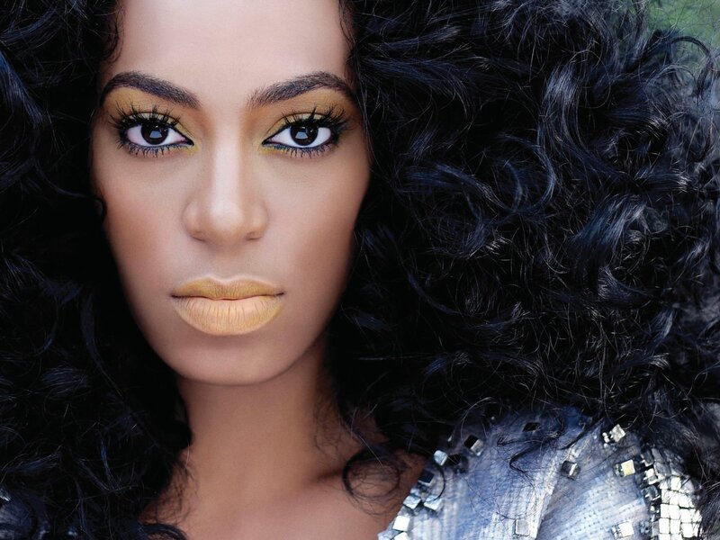 woman with curly hair and gold makeup