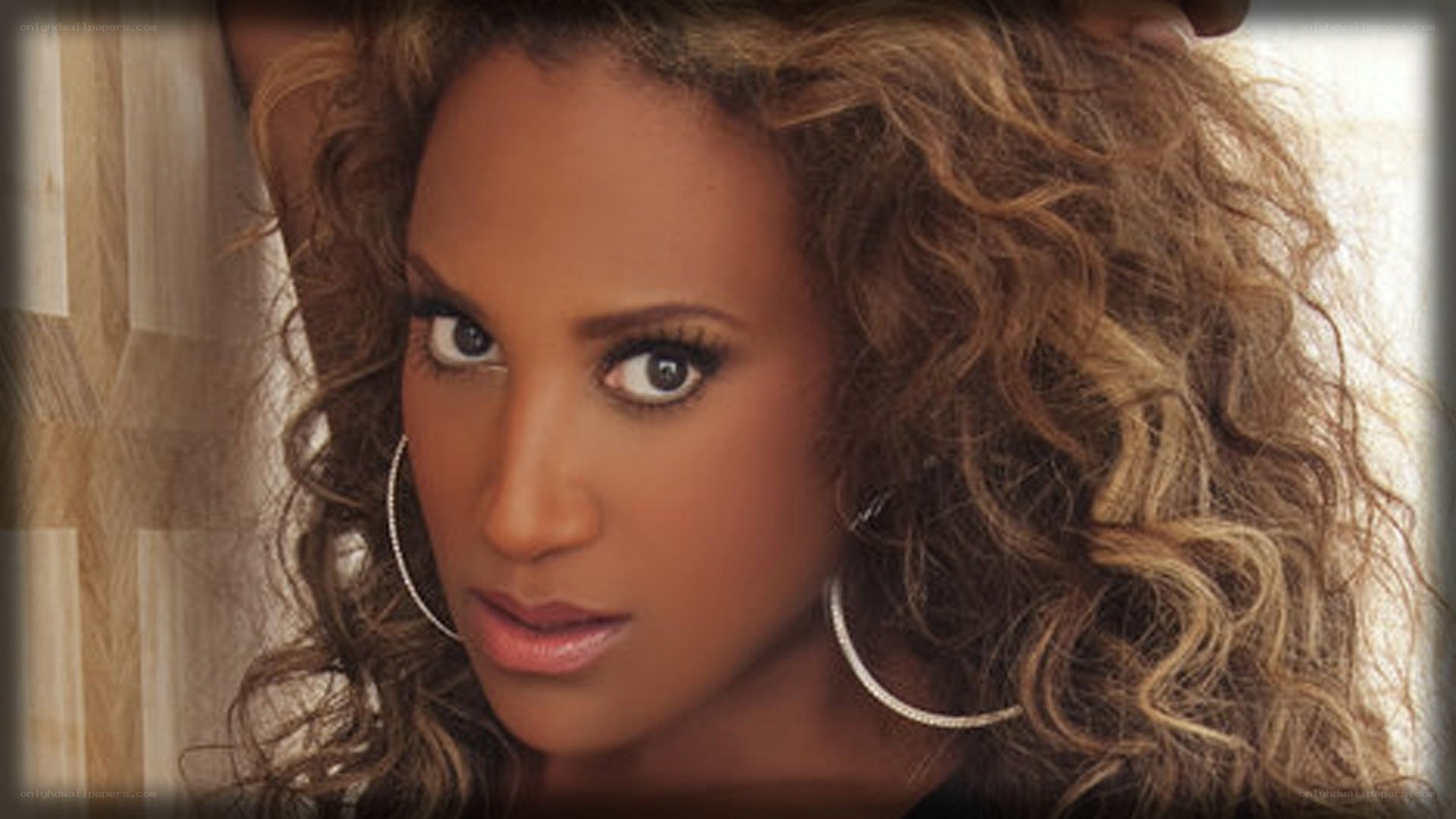 woman with curly hair and hoop earrings