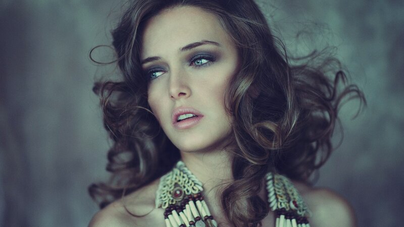 woman with curly hair and necklace