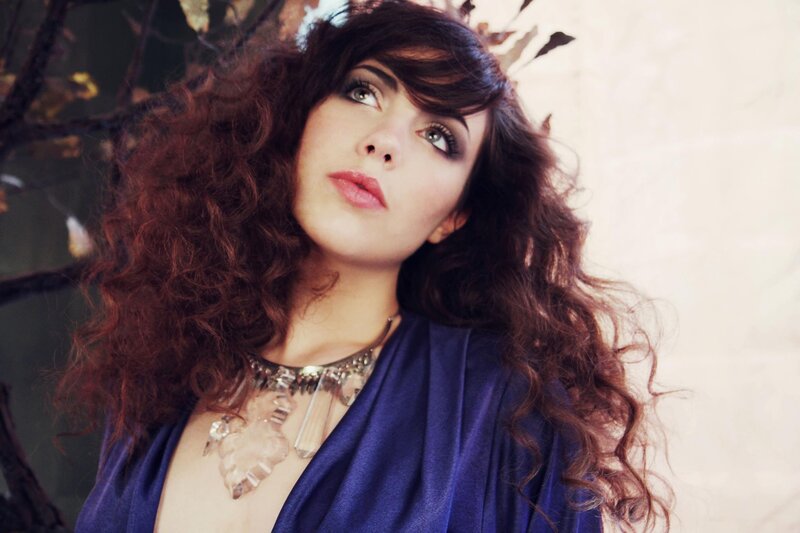woman with curly hair and necklace