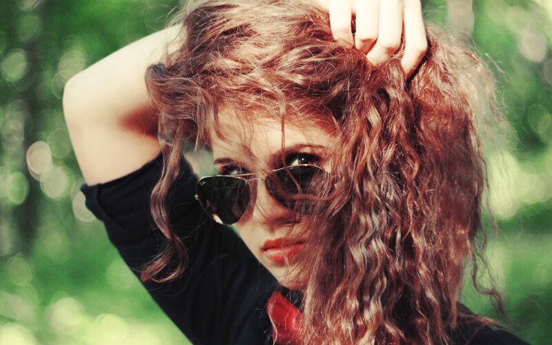 woman with curly hair and sunglasses