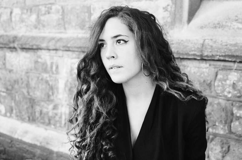 Woman with Curly Hair — Black, Contemplative, Photograph, Brick Wall
