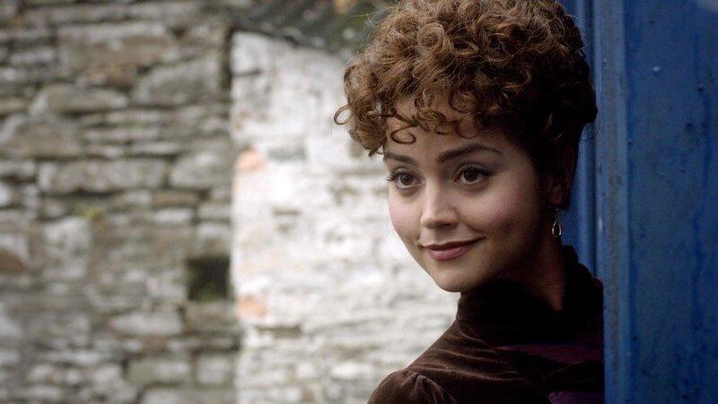 woman with curly hair by blue door