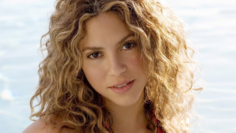 woman with curly hair by water