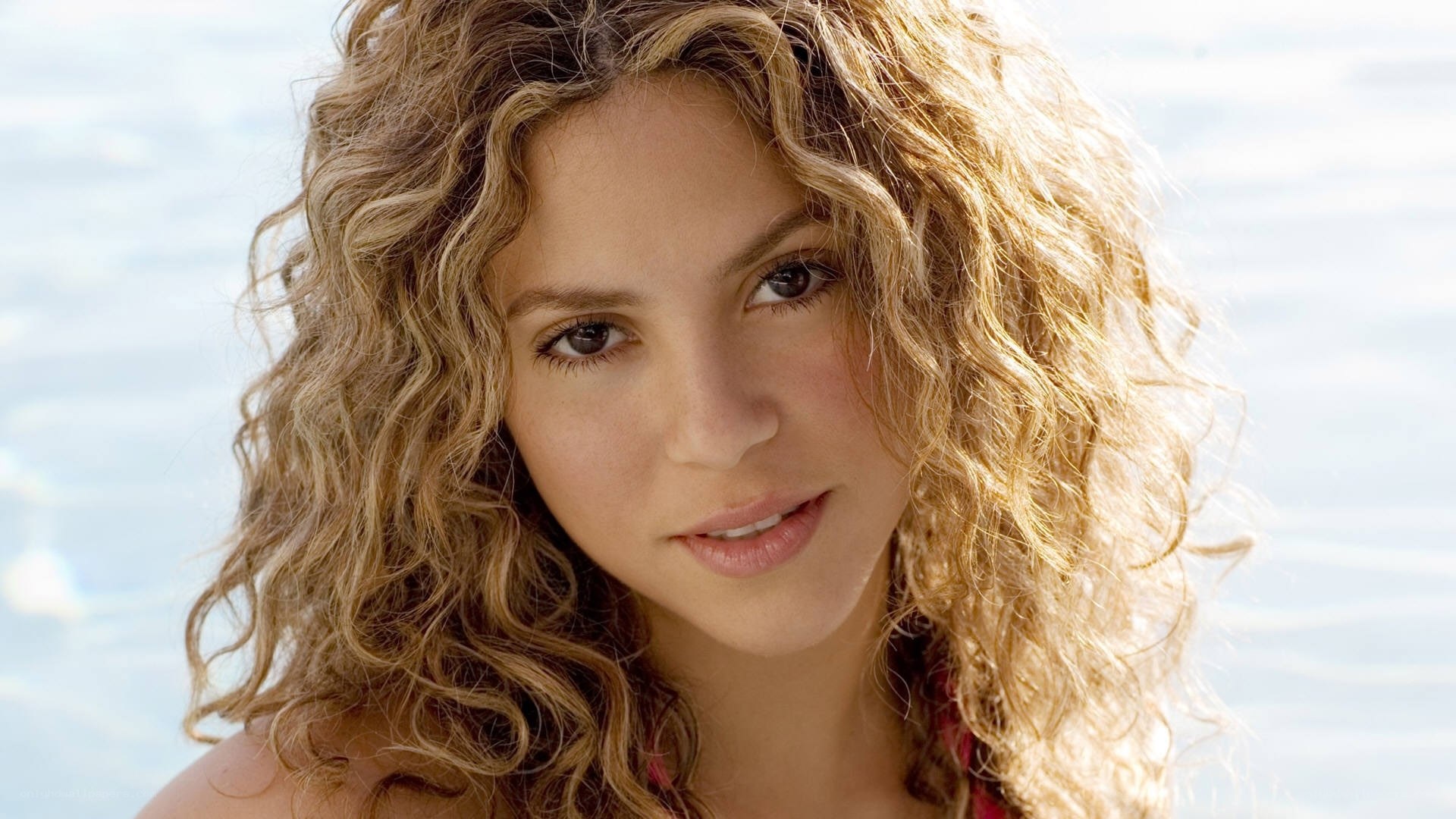 woman with curly hair by water