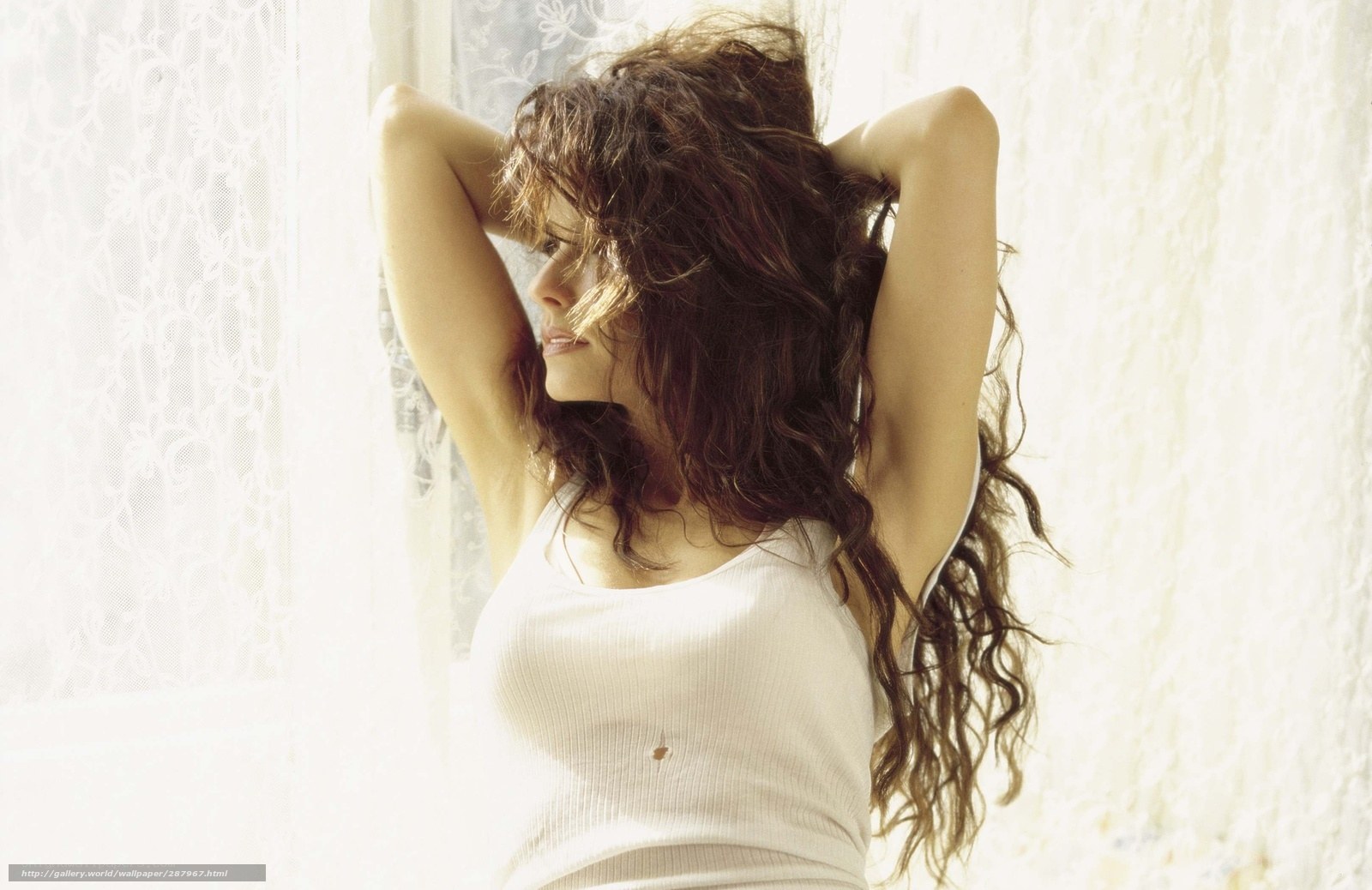 woman with curly hair by window