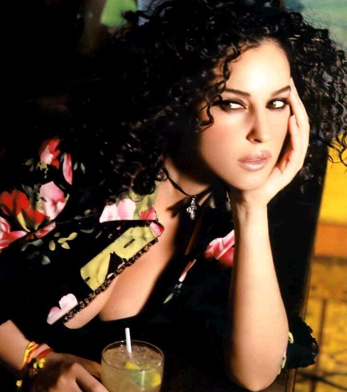 woman with curly hair holding drink