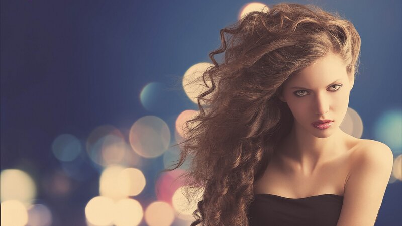 woman with curly hair in city lights
